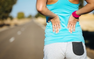 Picture of woman holding sore lower back